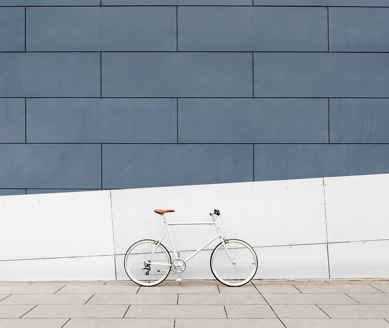 trendy white bike leaning against wall